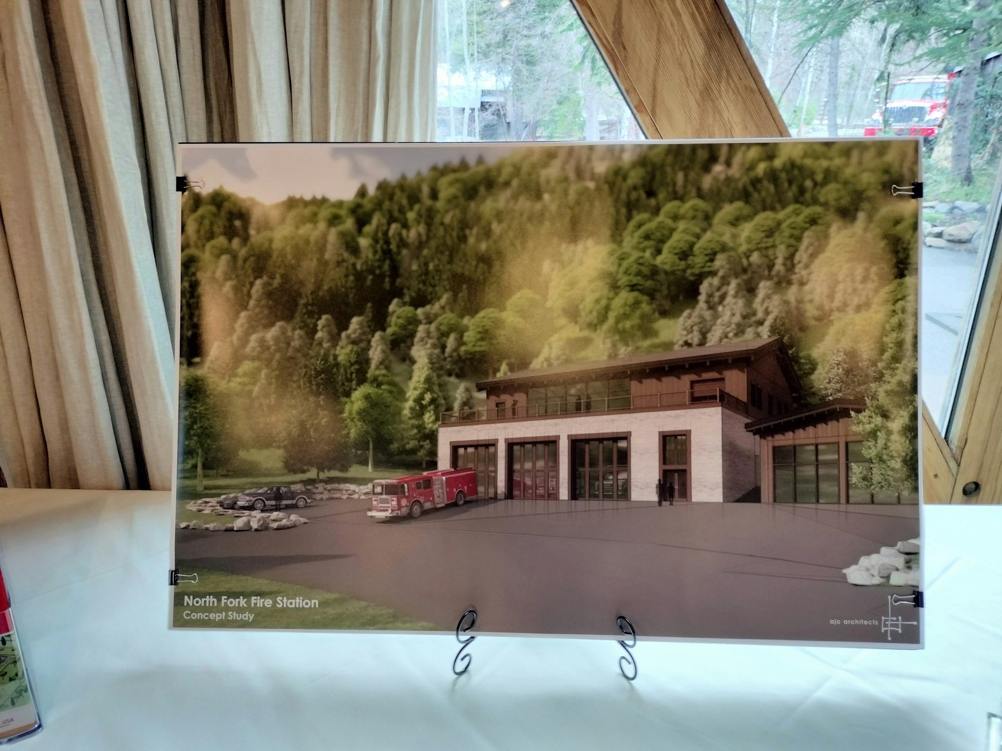 An architectural concept study poster of the North Fork Fire Station with trees in the background.