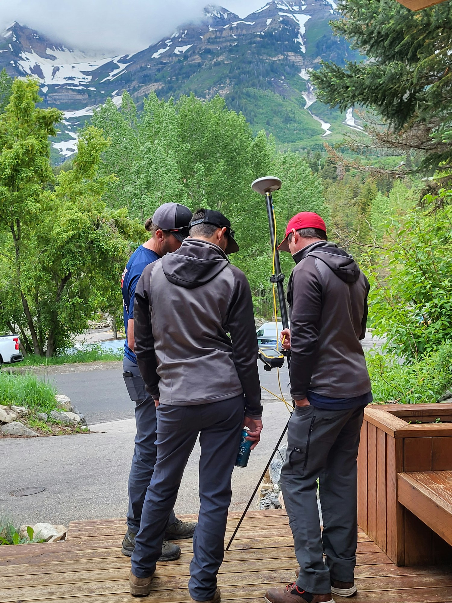 Two hikers with trekking poles and a mountainous background, image rotated 90 degrees clockwise.