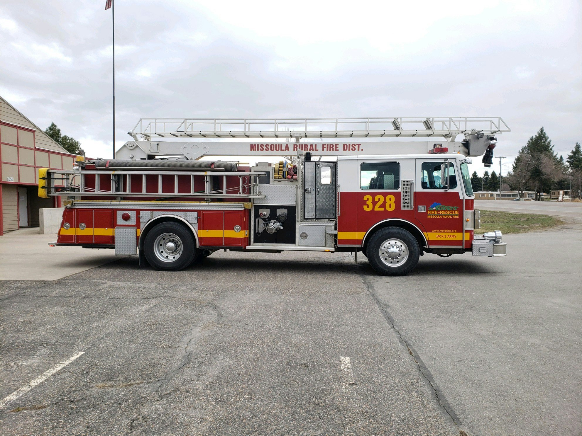 A red and white fire truck labeled "Missoula Rural Fire Dist. 328" parked outside a building.