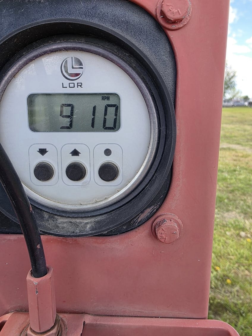 The image shows a digital RPM gauge displaying 910 RPM, likely from a piece of machinery.