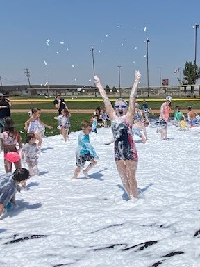 People enjoying a foam party outdoors, with a joyful atmosphere.