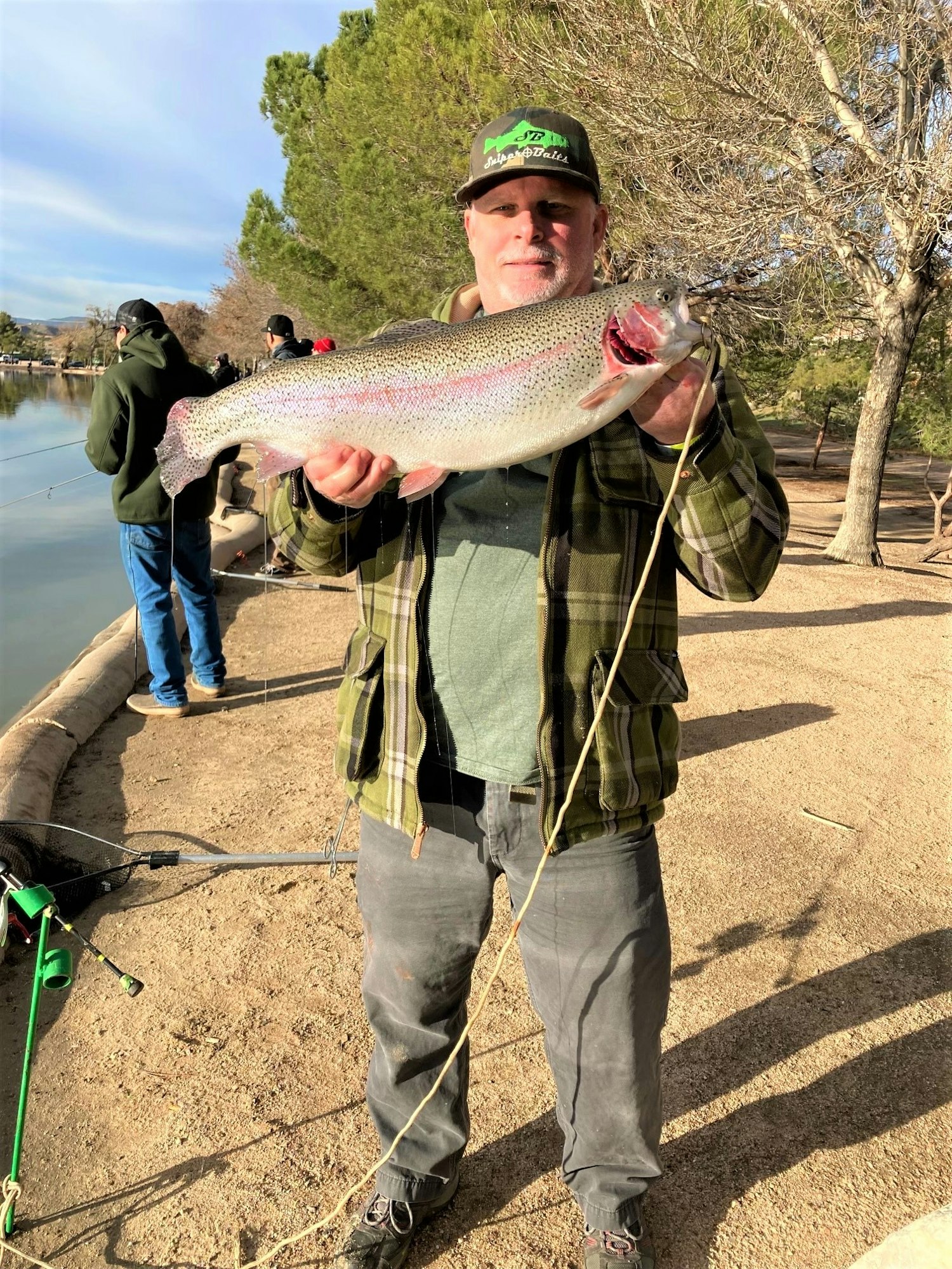 May contain: soil, trout, fish, sea life, animal, portrait, person, photography, head, face, fishing, outdoors, water, leisure activities, shoe, footwear, and clothing