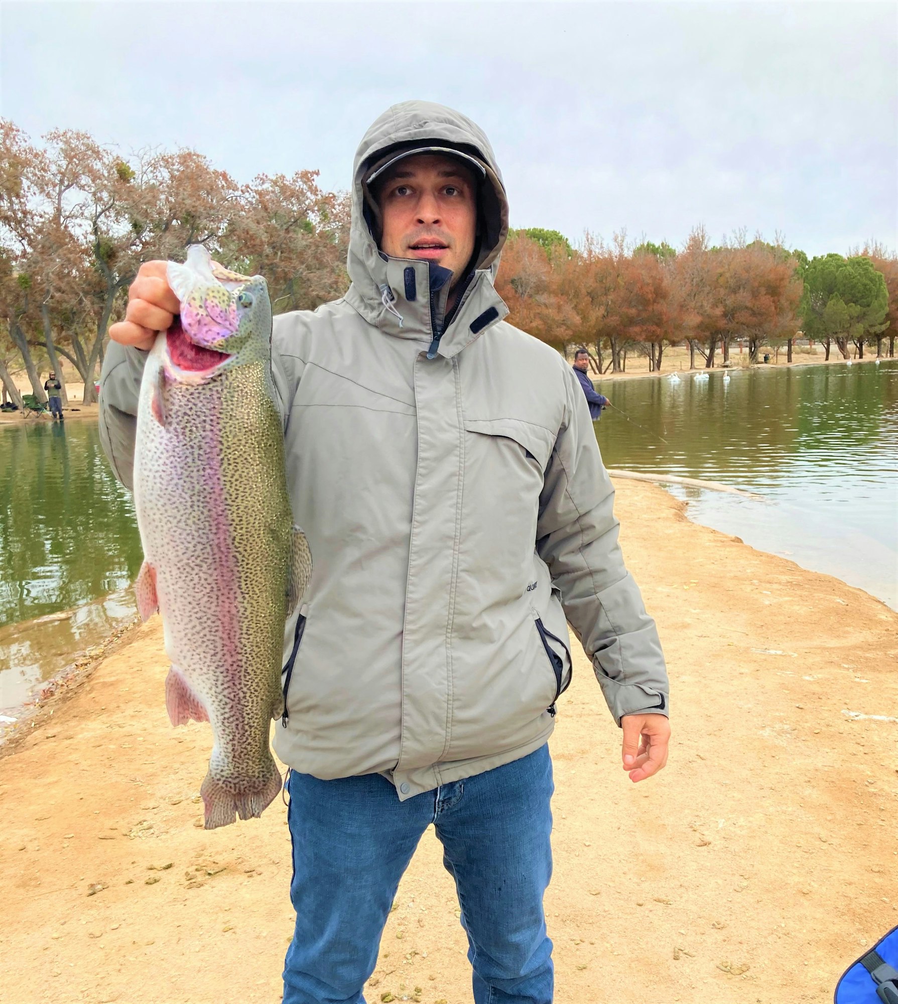 May contain: coat, clothing, jacket, photography, portrait, person, head, face, man, adult, male, fish, sea life, animal, hoodie, sweatshirt, sweater, knitwear, outdoors, trout, water, and pants