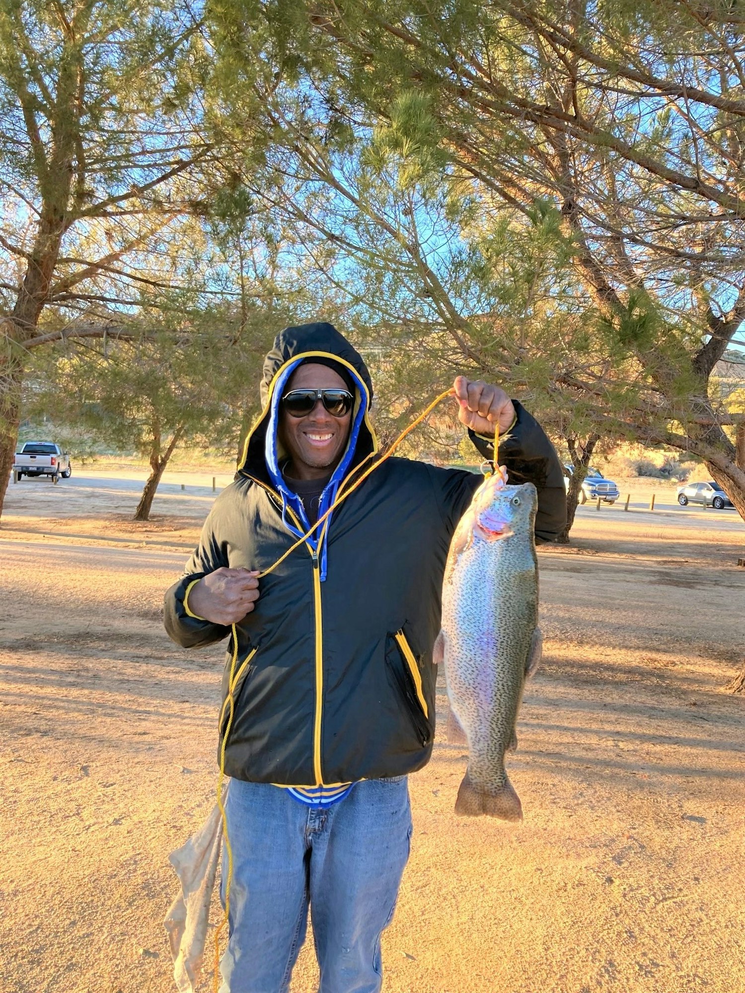 May contain: portrait, photography, person, head, face, soil, jacket, coat, clothing, tree, plant, pants, vegetation, park, grass, outdoors, nature, sunglasses, accessories, woodland, land, trout, fish, sea life, animal, grove, jeans, rock, car, vehicle, transportation, bonito, tuna, glasses, wilderness, pickup truck, truck, baseball cap, hat, cap, fishing, water, and leisure activities