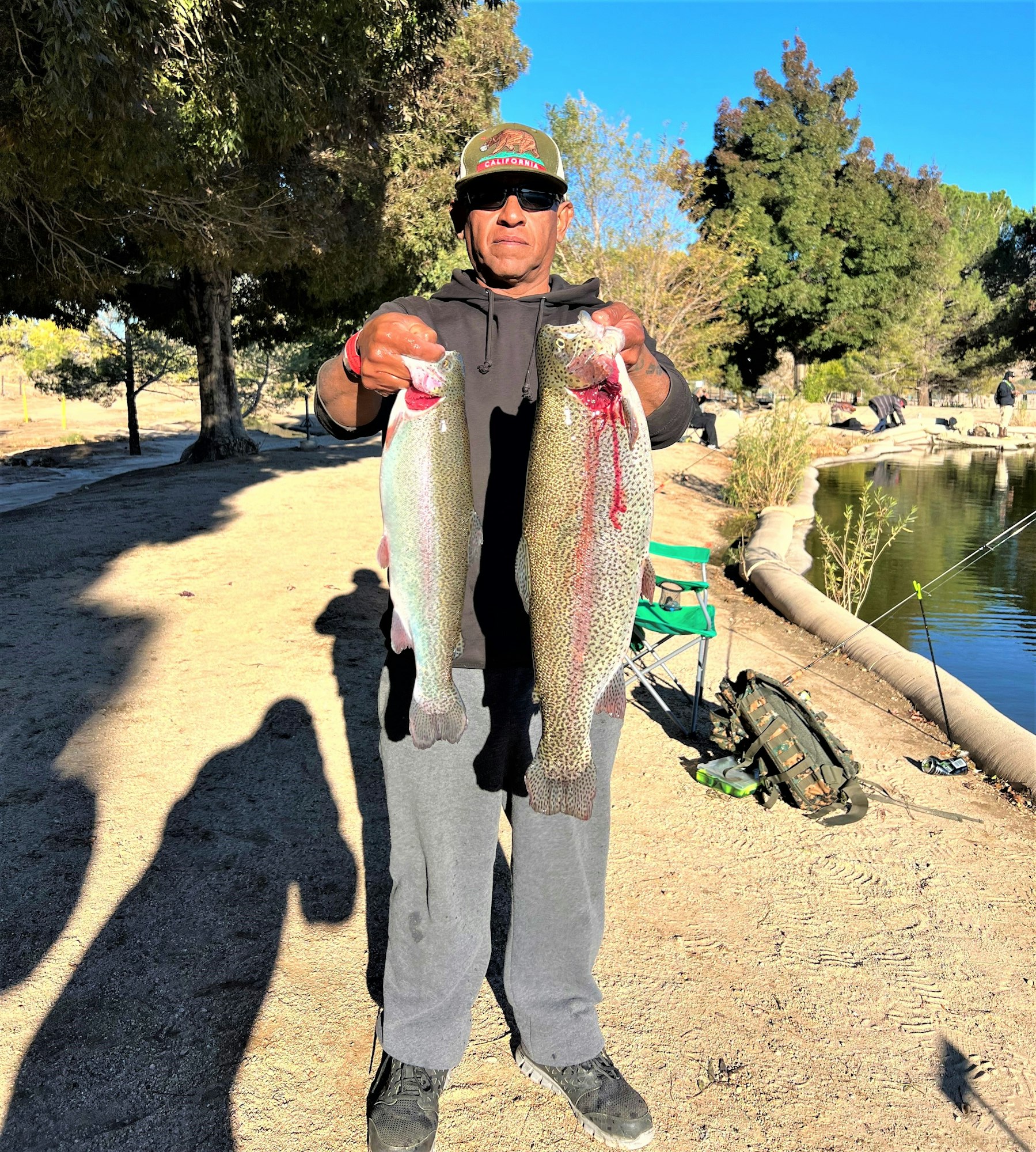 May contain: trout, fish, sea life, animal, portrait, photography, person, head, face, fishing, outdoors, water, leisure activities, soil, tree, and plant