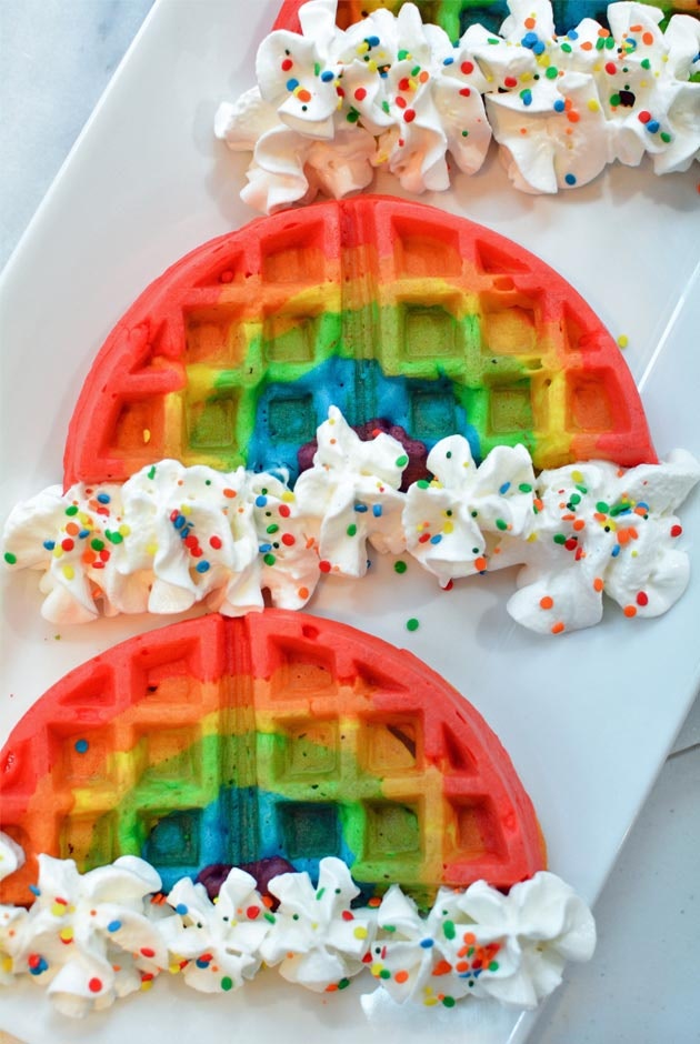 Rainbow waffles with whipped cream clouds and rainbow sprinkles