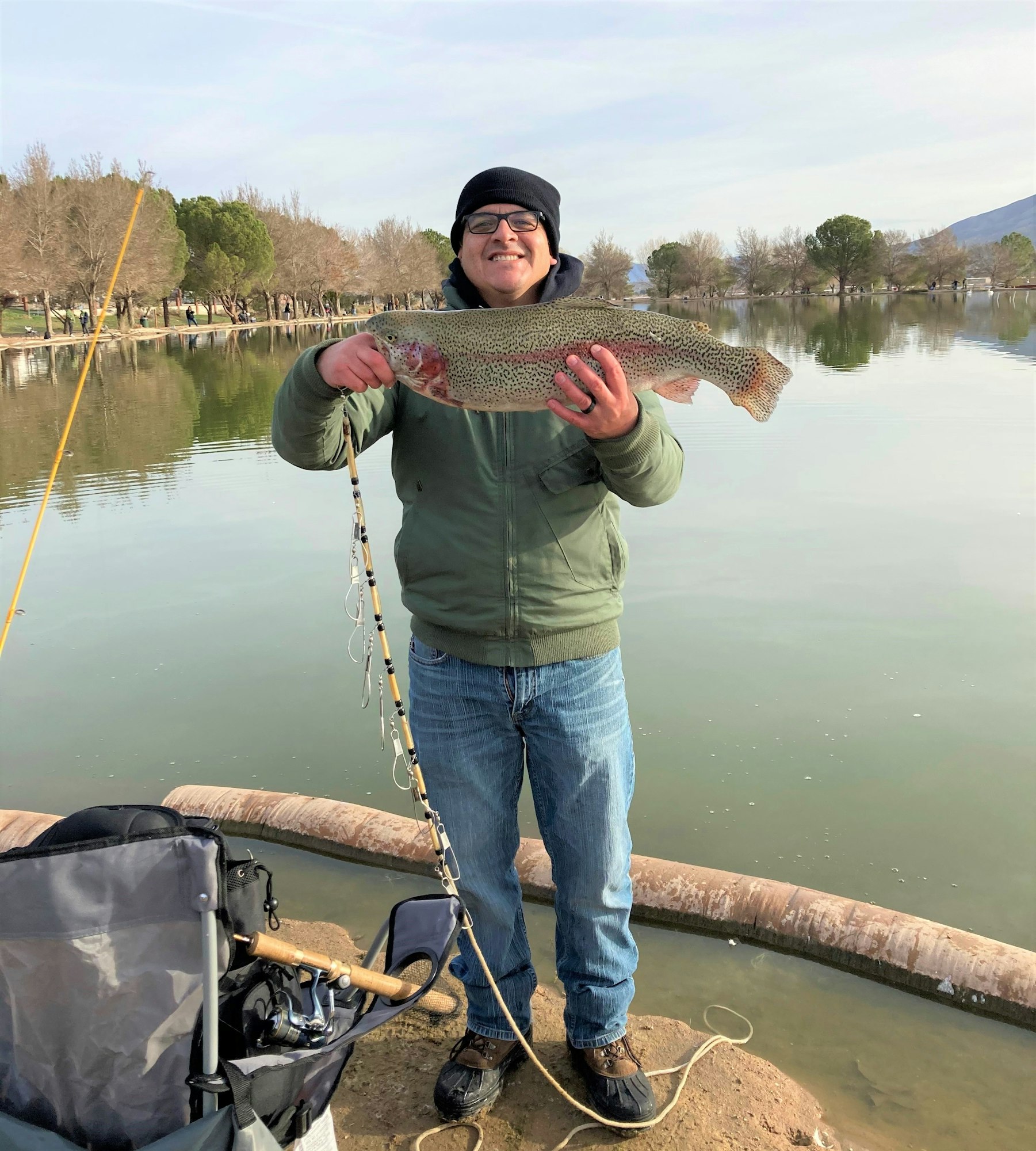 May contain: pants, clothing, fishing, outdoors, water, leisure activities, shoe, footwear, glasses, accessories, person, fish, sea life, animal, trout, lake, and nature
