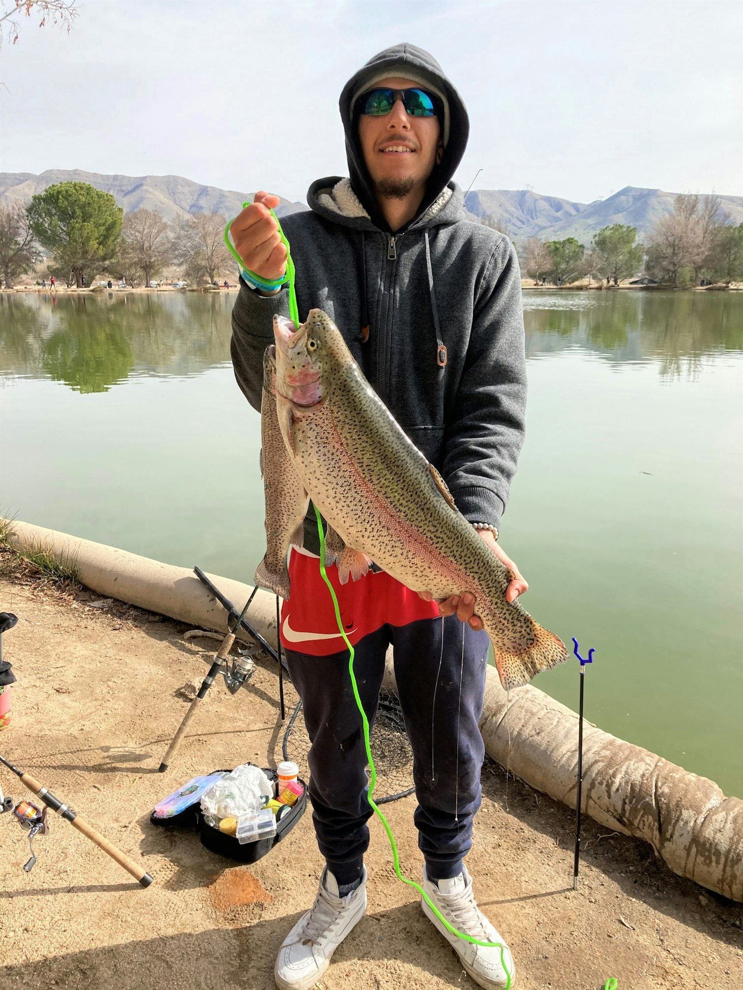May contain: fishing, outdoors, water, leisure activities, trout, sea life, fish, animal, person, portrait, photography, head, face, shoe, footwear, clothing, lake, and nature
