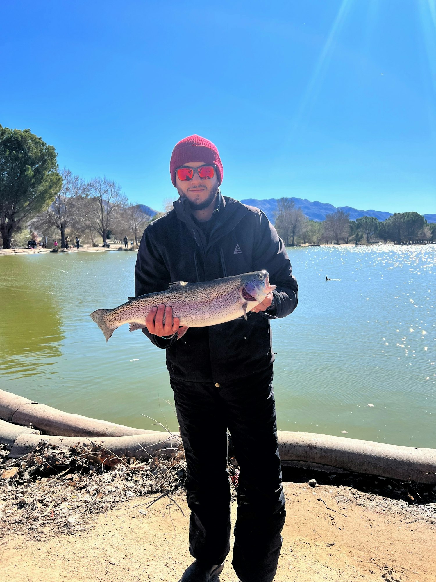 May contain: fish, sea life, animal, coho, person, man, adult, male, trout, glasses, accessories, hat, and clothing