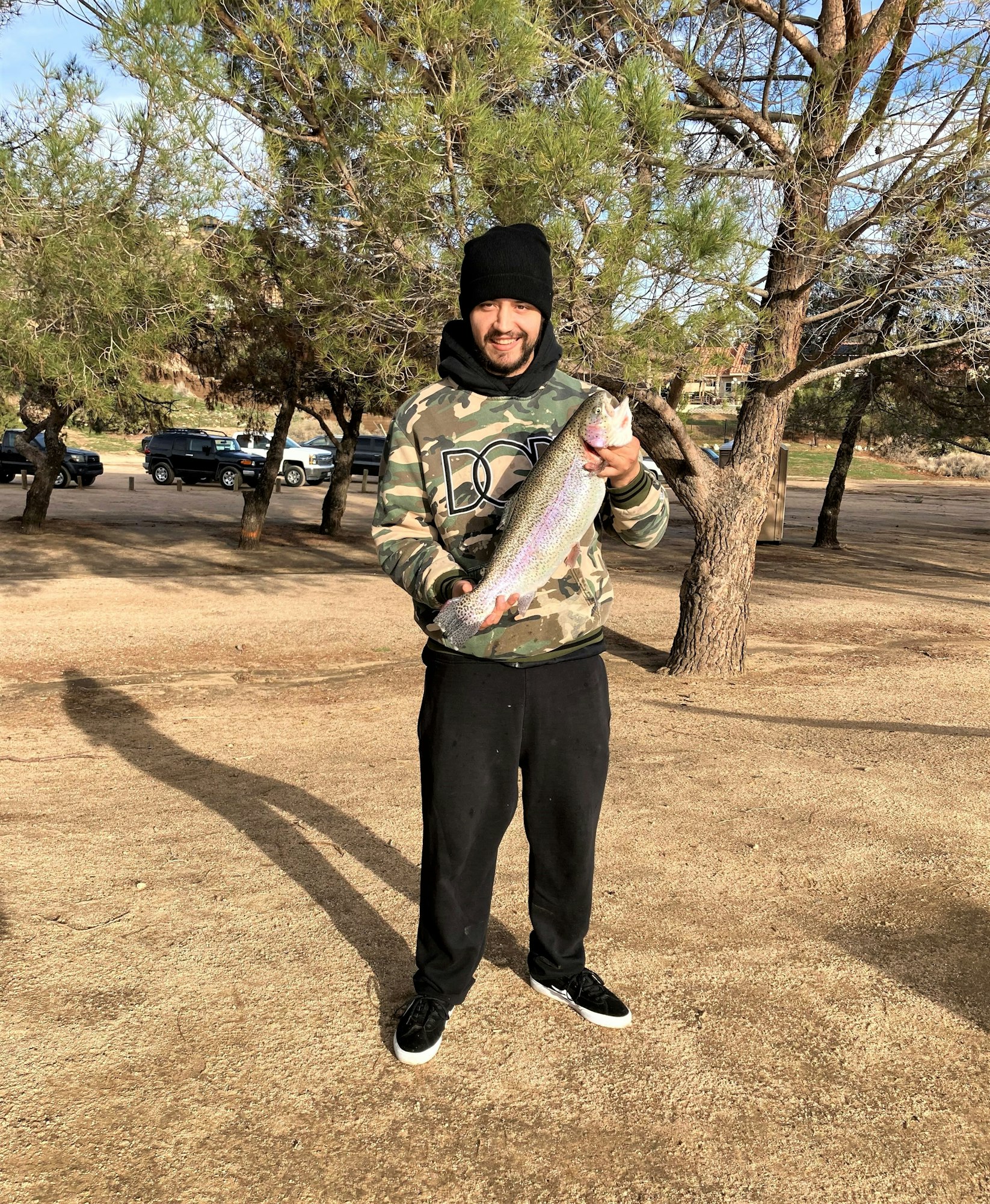 May contain: portrait, photography, person, head, face, park, grass, outdoors, nature, plant, grove, tree, vegetation, woodland, land, soil, pants, clothing, hat, bonito, fish, tuna, sea life, animal, jacket, coat, rock, car, vehicle, transportation, tree trunk, shoe, footwear, trout, standing, and wilderness