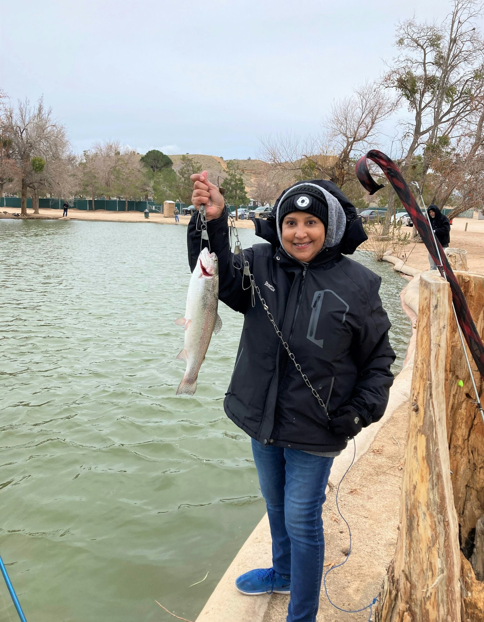 May contain: portrait, photography, person, head, face, jacket, coat, clothing, pants, tree, plant, waterfront, water, glove, fishing, outdoors, leisure activities, jeans, wood, shoe, and footwear