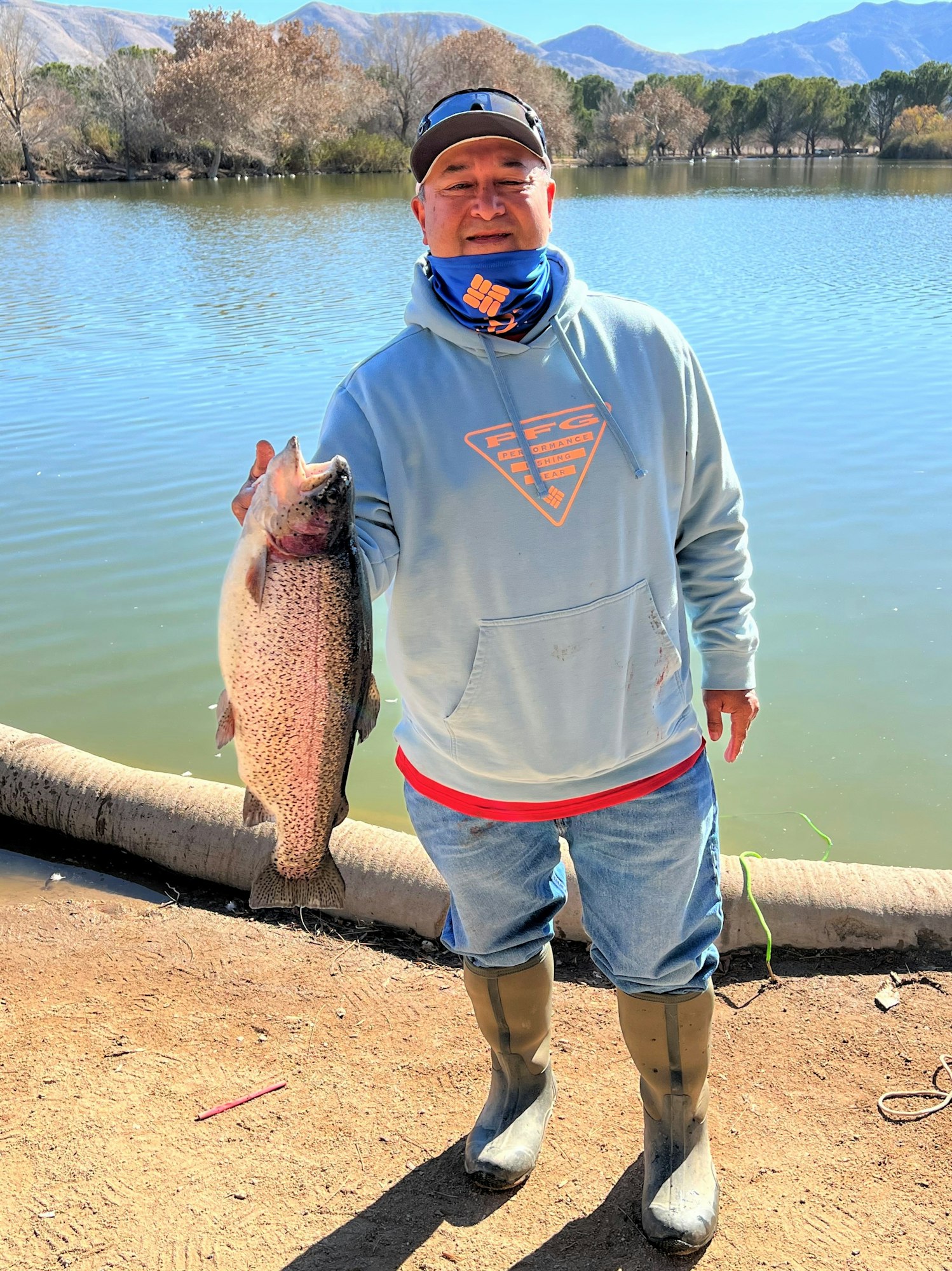 May contain: portrait, photography, person, head, face, fish, sea life, animal, fishing, outdoors, water, leisure activities, waterfront, man, adult, male, trout, hoodie, sweatshirt, sweater, clothing, knitwear, shoe, and footwear