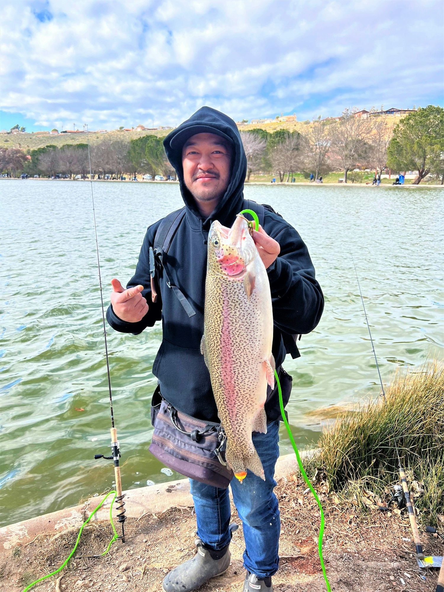 May contain: fishing, outdoors, water, leisure activities, portrait, photography, person, head, face, fish, sea life, animal, woman, adult, female, pants, clothing, shoe, footwear, trout, jacket, coat, soil, and angler