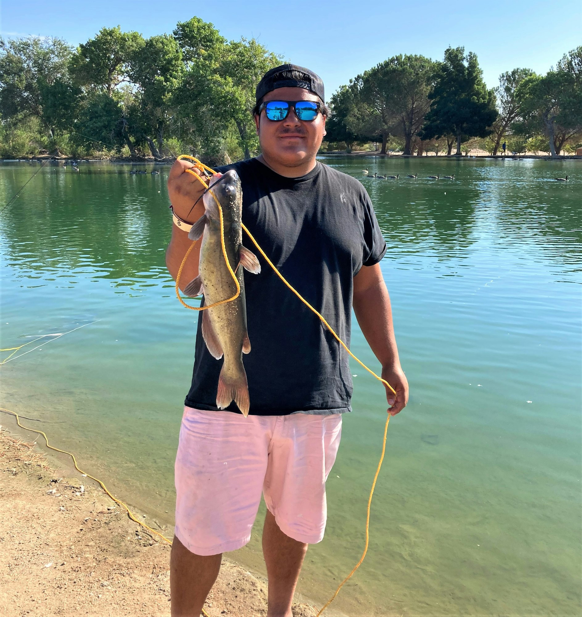 May contain: water, outdoors, person, human, trout, animal, fish, fishing, shorts, clothing, and apparel