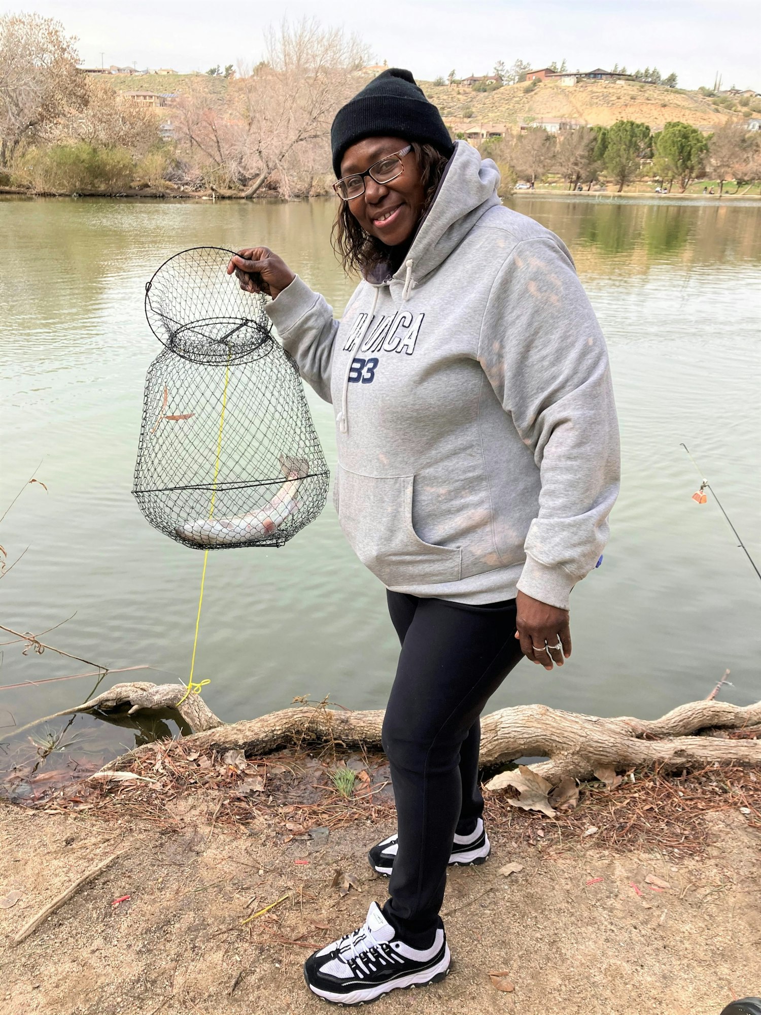 May contain: shoe, footwear, clothing, fishing, water, outdoors, leisure activities, portrait, photography, person, head, face, standing, hoodie, sweater, sweatshirt, knitwear, rock, sneaker, and sitting