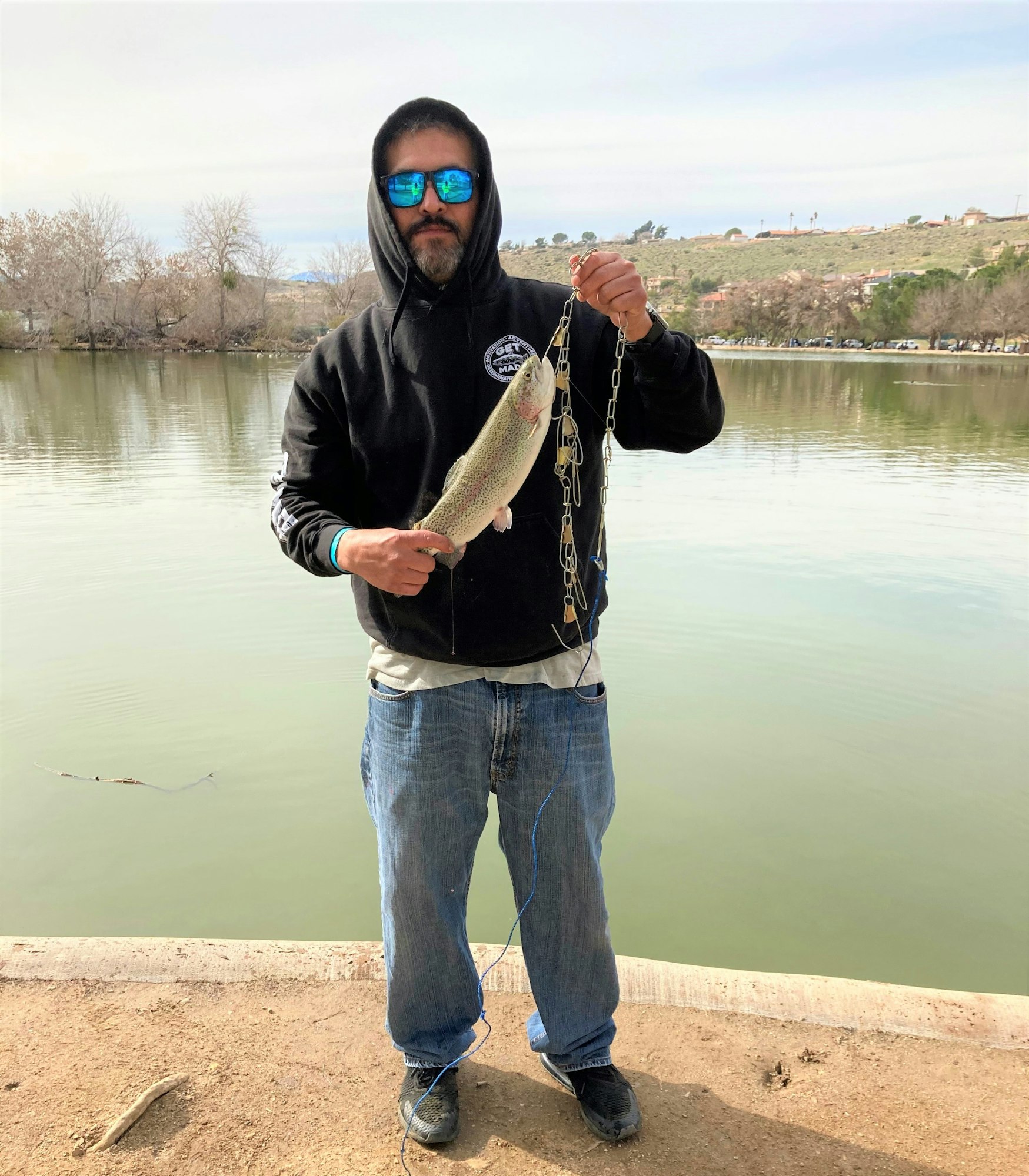 May contain: pants, clothing, jeans, hoodie, sweatshirt, sweater, knitwear, fishing, outdoors, water, leisure activities, trout, sea life, fish, animal, standing, person, portrait, photography, head, and face
