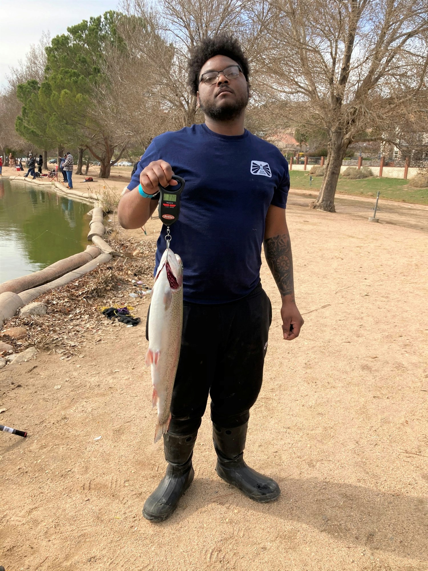 May contain: portrait, photography, person, head, face, standing, park, grass, outdoors, plant, nature, tree, vegetation, t-shirt, clothing, man, adult, male, glasses, accessories, pants, fish, sea life, animal, fishing, water, leisure activities, bonito, tuna, shoe, and footwear
