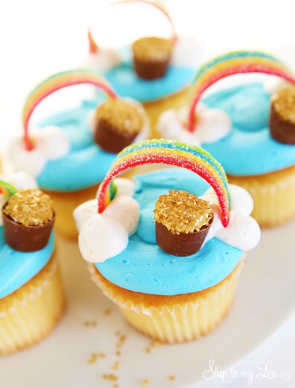 Cupcakes with blue frosting, white frosting clouds, a rolo with gold sprinkles and an airheads extreme