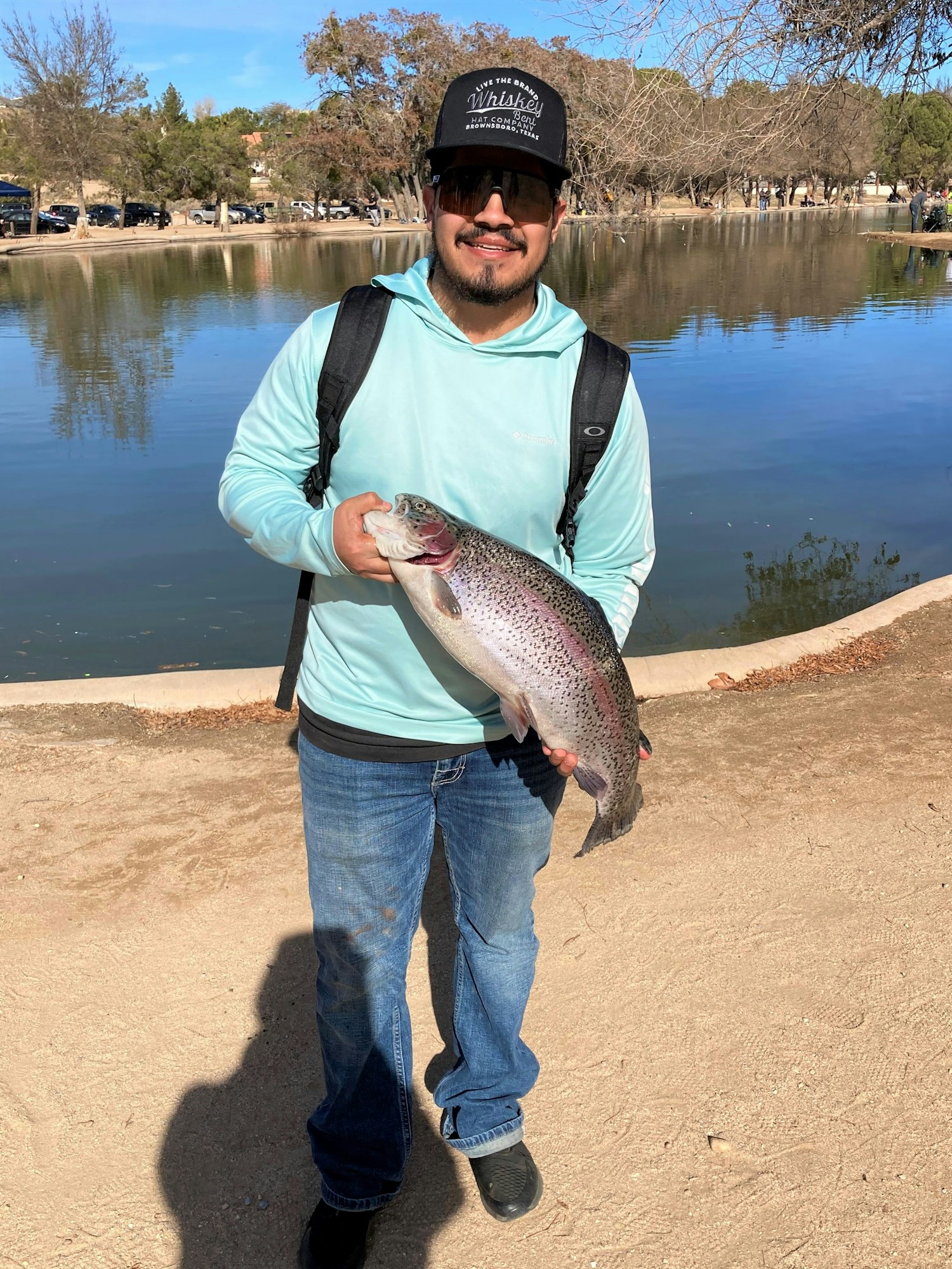 May contain: portrait, photography, person, head, face, pants, clothing, soil, jeans, fish, sea life, animal, fishing, outdoors, water, leisure activities, waterfront, trout, lake, nature, shoe, footwear, car, vehicle, transportation, tree, plant, bonito, and tuna