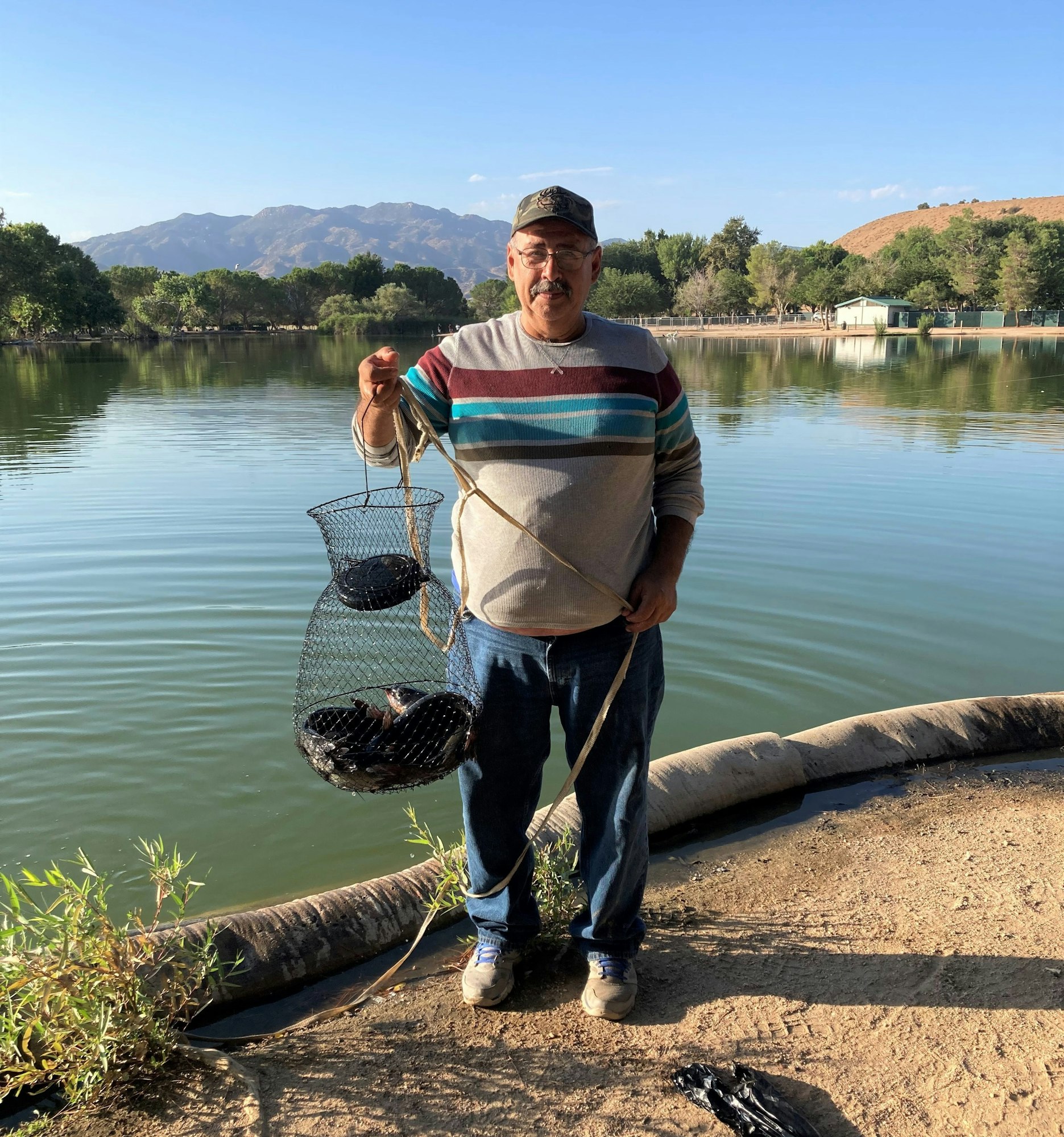 May contain: water, outdoors, person, human, fishing, nature, and land