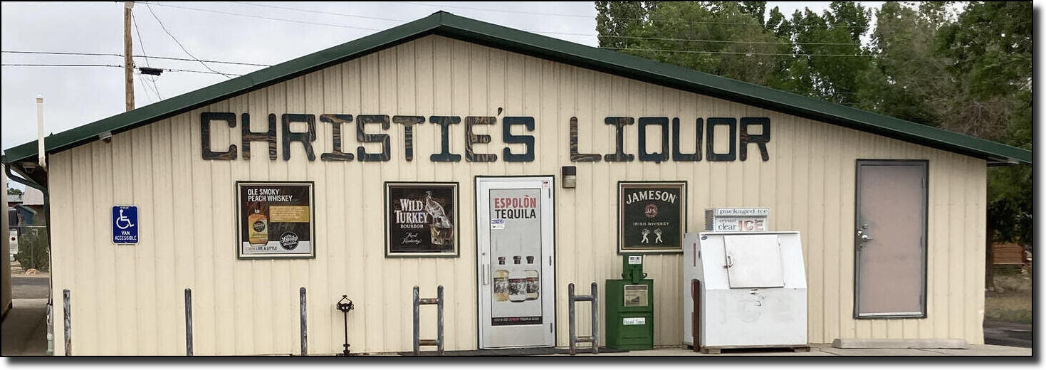 A small liquor store named "Christie's Liquor" with various alcohol advertisements and an ice machine outside.