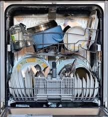 A dishwasher loaded with plates, bowls, utensils, and other kitchenware.
