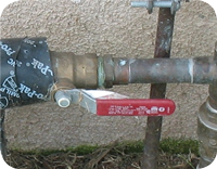 Pipe with valve and red handle locked with a padlock.