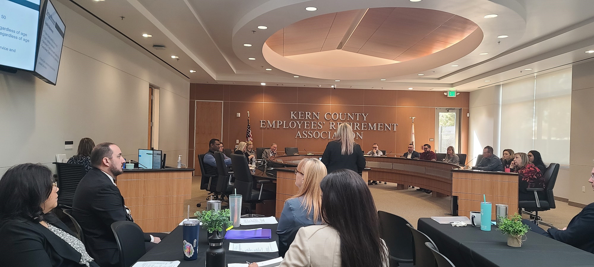 A meeting at the Kern County Employees' Retirement Association, with people seated in a conference room.