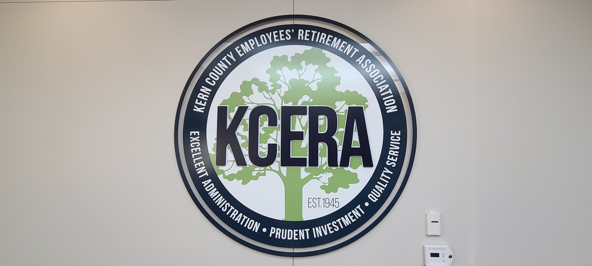 Logo of Kern County Employees' Retirement Association (KCERA) on a wall. Est. 1945, pledges excellent administration and investment.