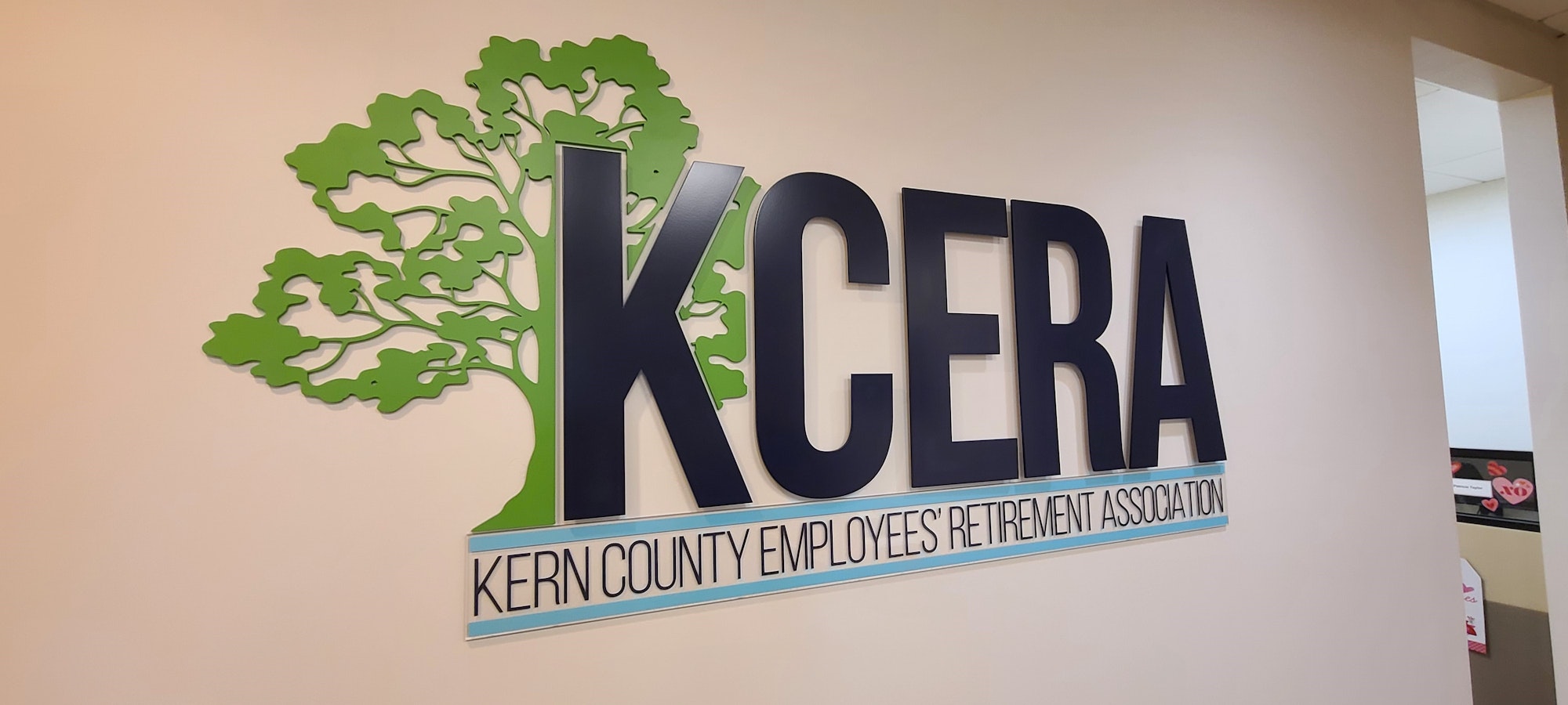 A wall sign of "KCERA - Kern County Employees' Retirement Association" with a green tree graphic.