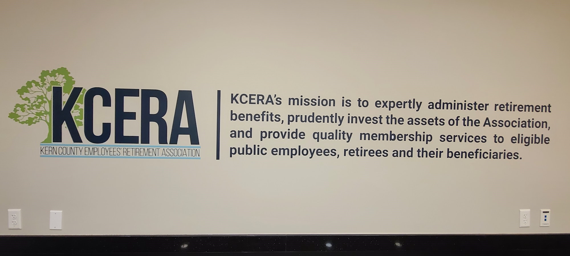 A logo with text about the Kern County Employees' Retirement Association's (KCERA) mission on a wall.