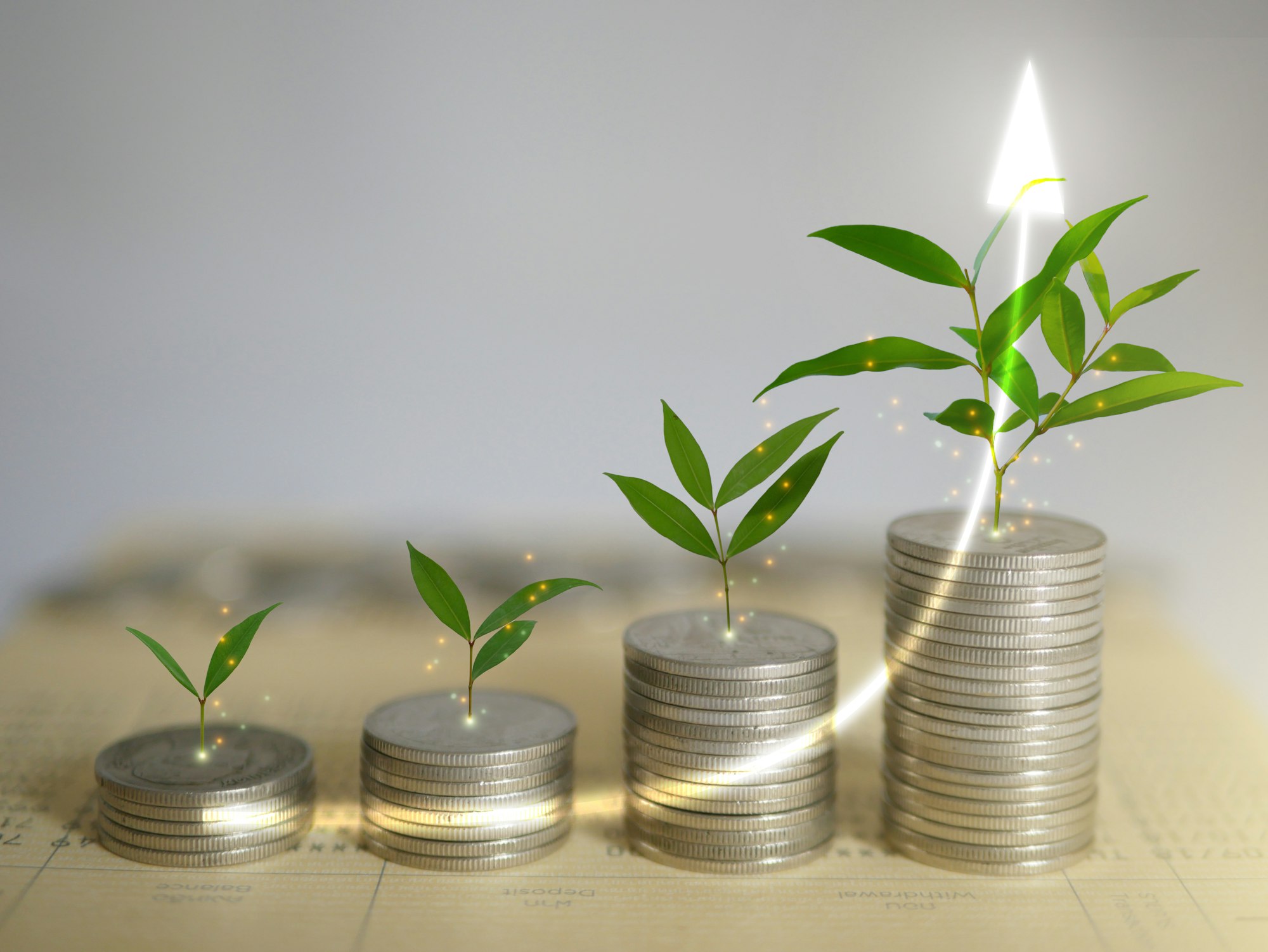 Plants growing from rising stacks of coins, symbolizing financial growth.