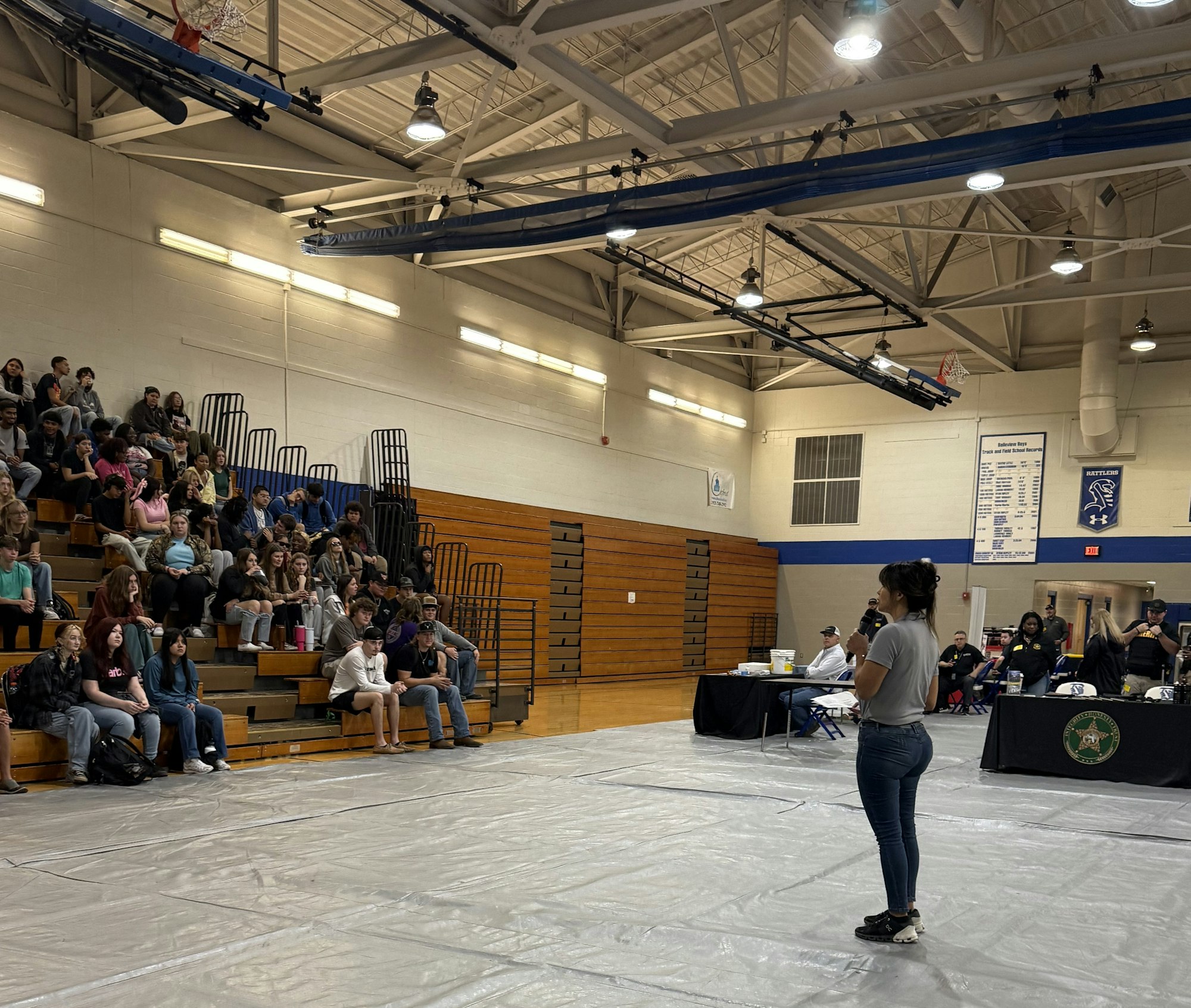A speaker addressing an audience in a school gymnasium.