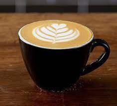 A cup of coffee with latte art on a table.