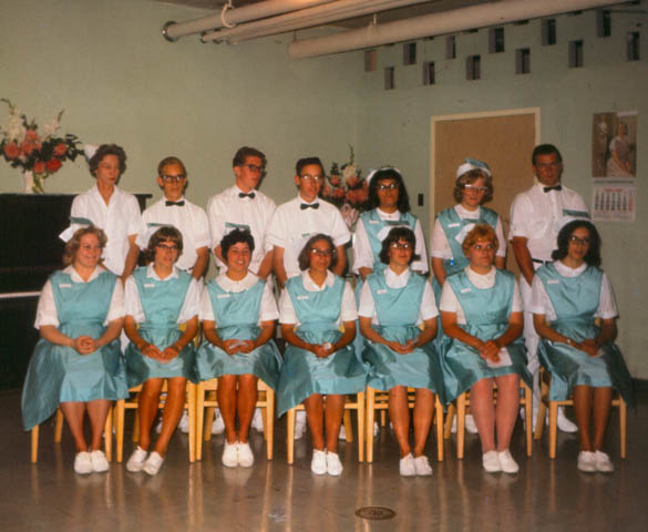 A group of people in matching uniforms posing for a photo, possibly healthcare workers or staff.