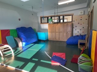 The St. Vincent Health Pediatric Occupational Therapy room, a colorful playroom with padded mats, bean bags, slides, and climbing wall.