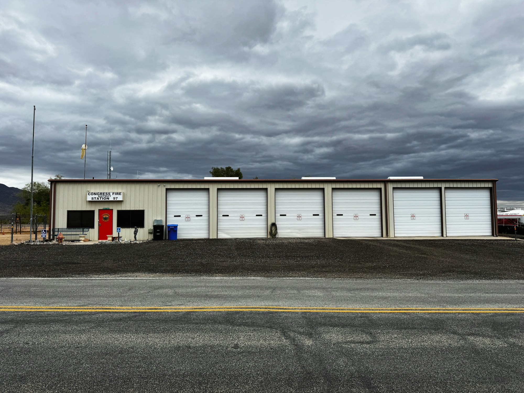 Fire station with four garage doors under a cloudy sky, marked as "Congress Fire Station 97".