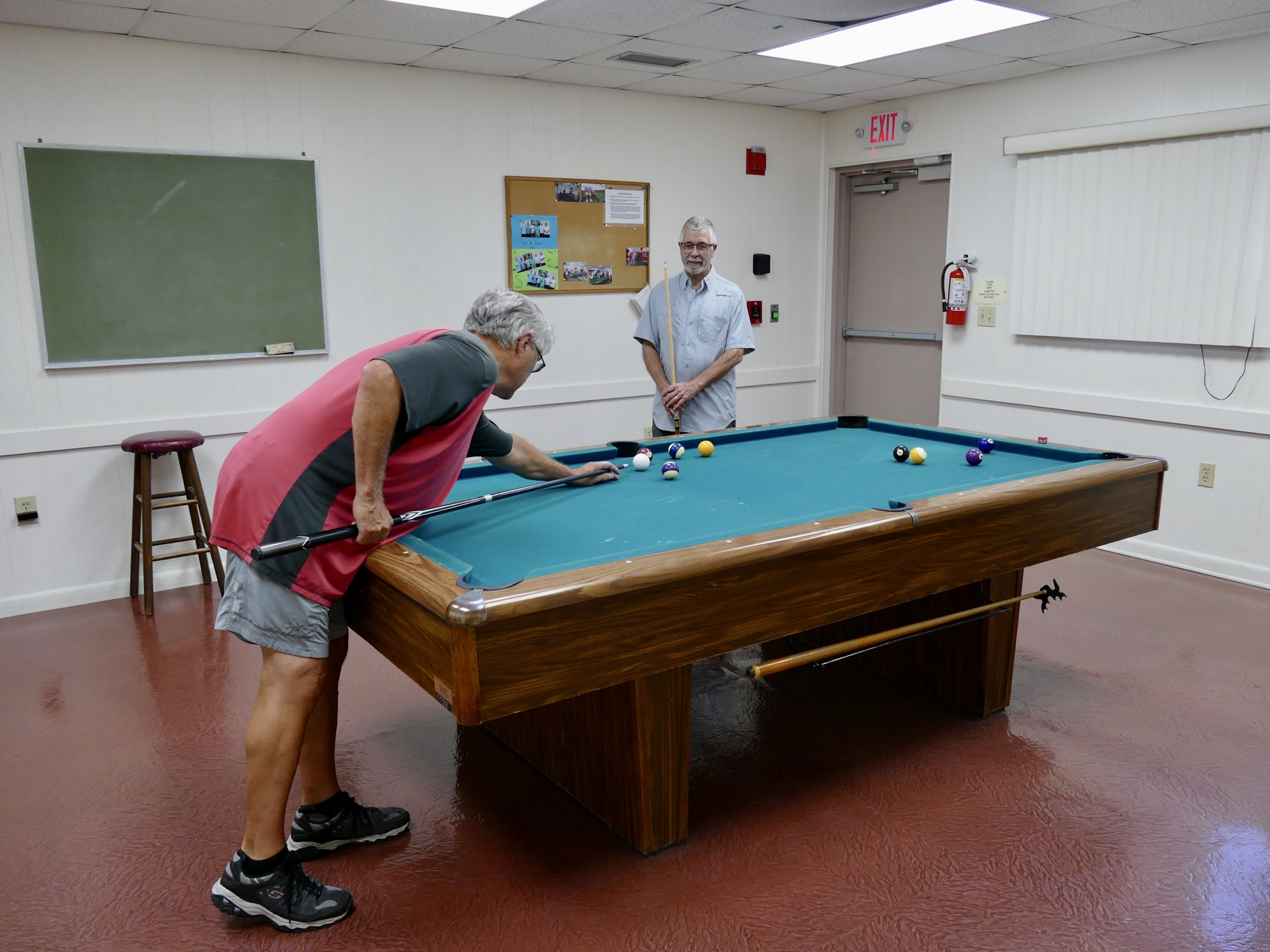 Picture of the Billiards Room with the table and two people playing pool