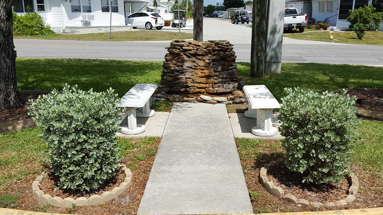Picture of stone statue with benches and shrubs