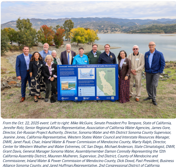 A group of people is standing outdoors by a lake, displaying a sign about reservoir operations at Lake Mendocino.