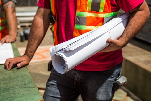 Image of a construction worker holding blueprints