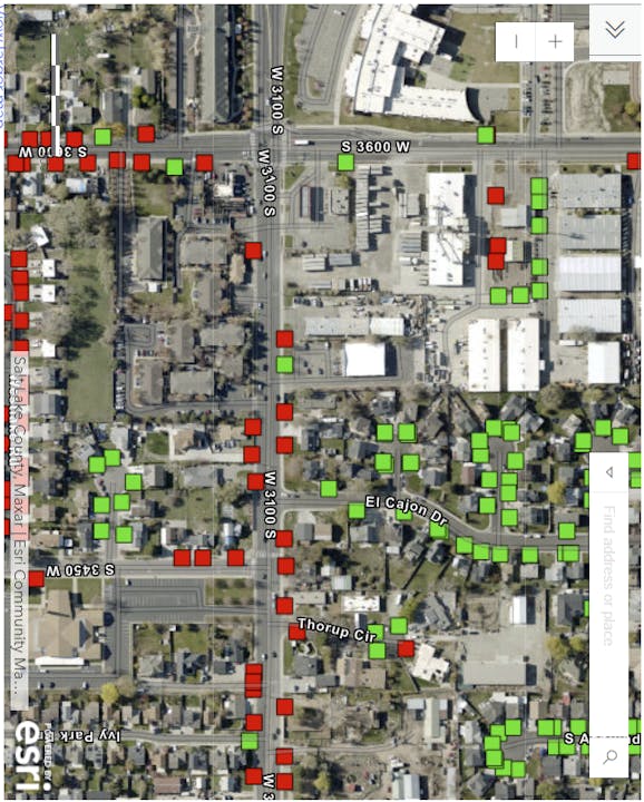 Aerial map view with green and red square markers, likely indicating status or data points on a grid of streets.