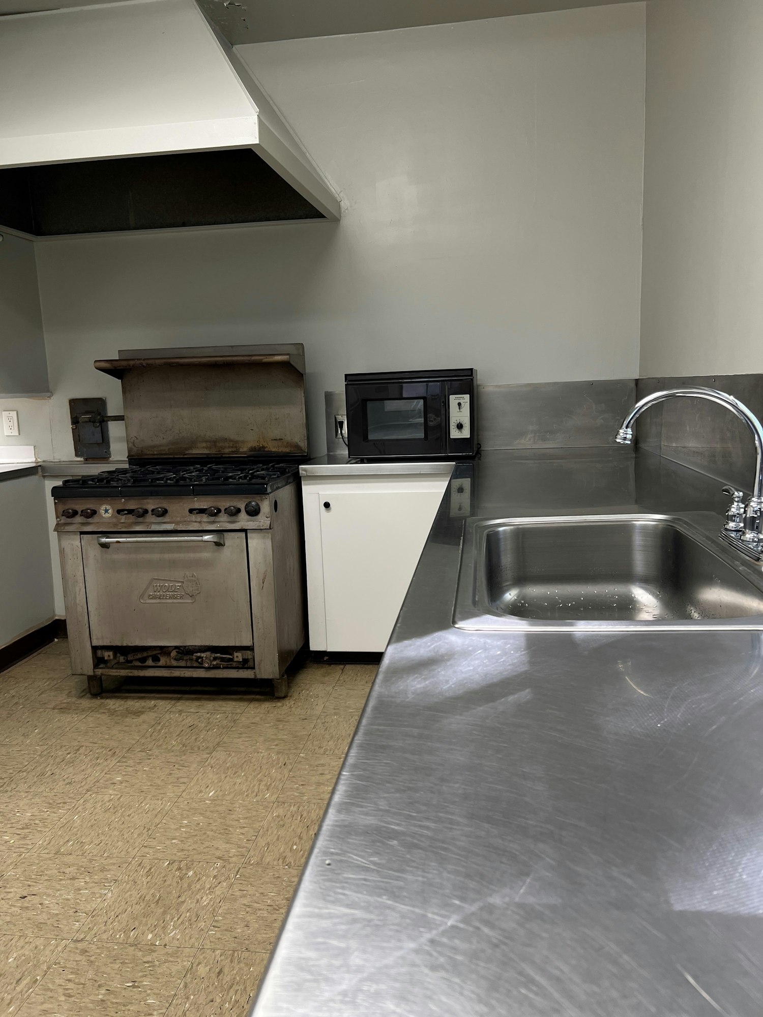 May contain: sink, indoors, kitchen, sink faucet, floor, appliance, device, electrical device, microwave, oven, and interior design