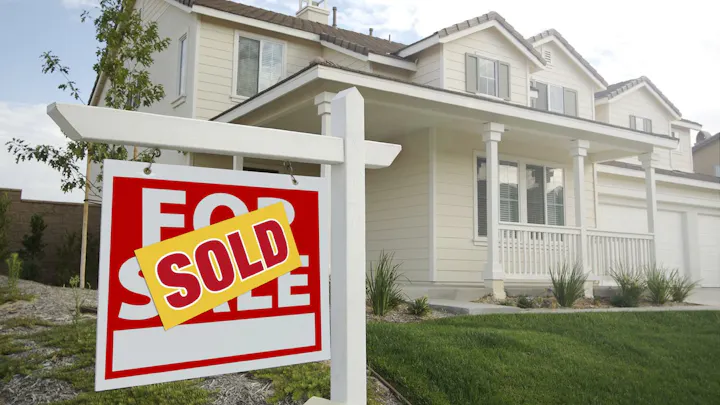A house with a "Sold" sign in front, indicating it has been purchased.