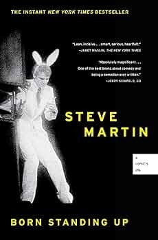A book cover titled "Born Standing Up" by Steve Martin, featuring an individual in a suit and bunny ears.