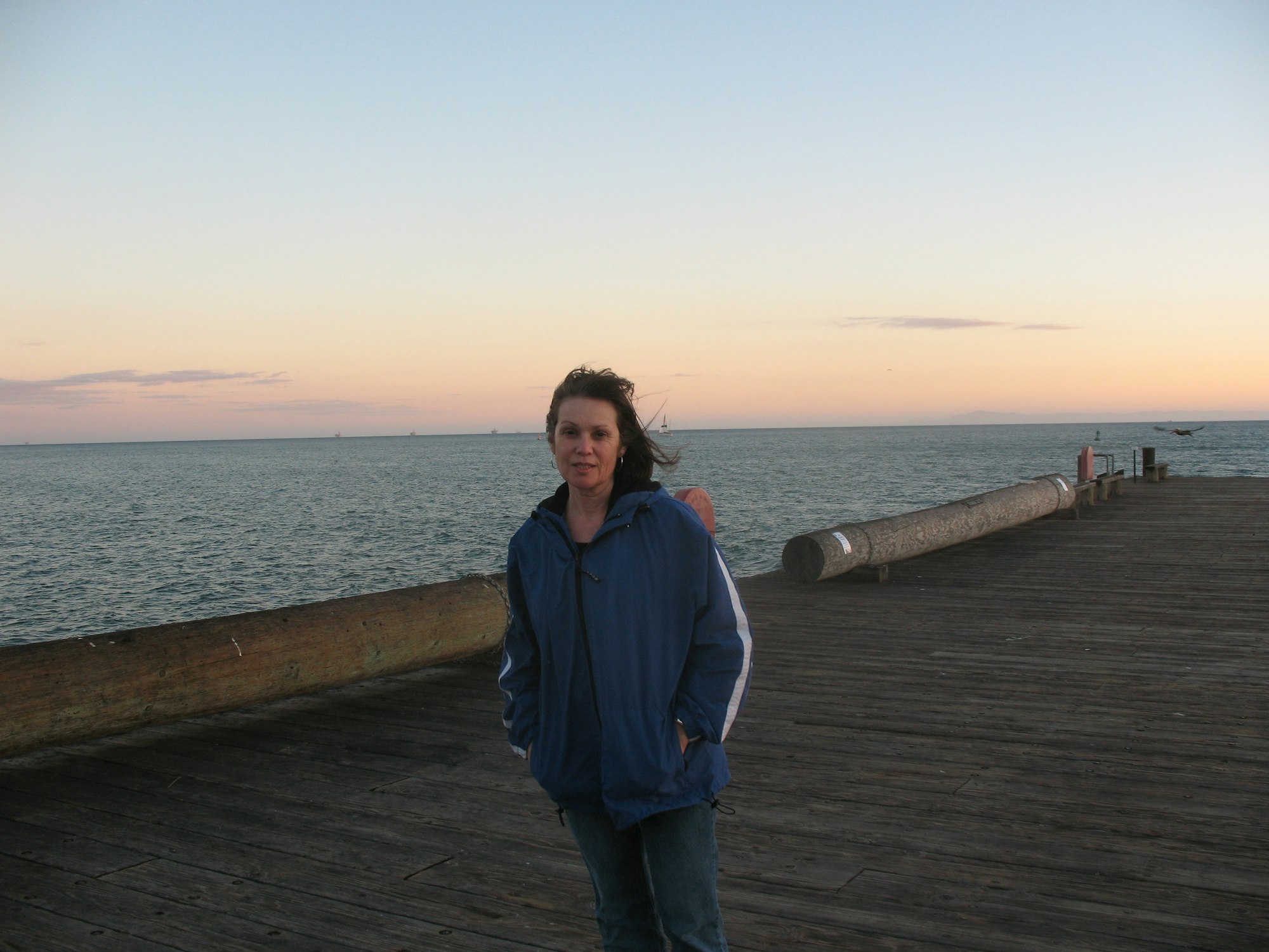 Photo of Executive Director standing on a dock at the ocean.