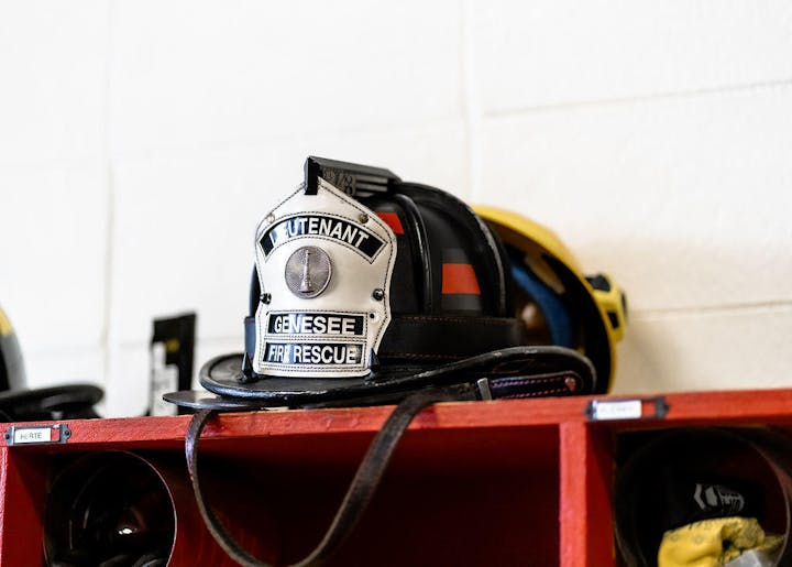 A firefighter's helmet labeled "Lieutenant" on a shelf with other gear.