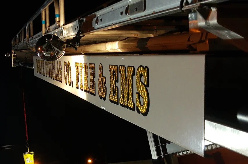 A lit sign on a fire truck reading "North Douglas County Fire & EMS" at night.