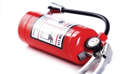 A red fire extinguisher with a pressure gauge and instructions label.