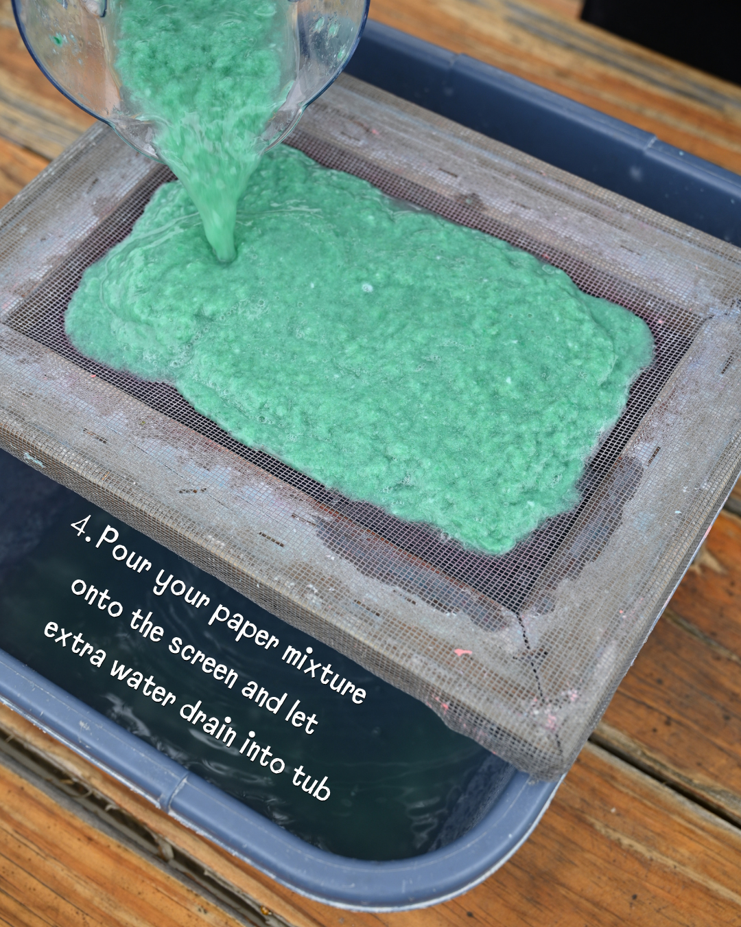 A paper-making process step: pouring a green mixture onto a screen to drain excess water into a tub.